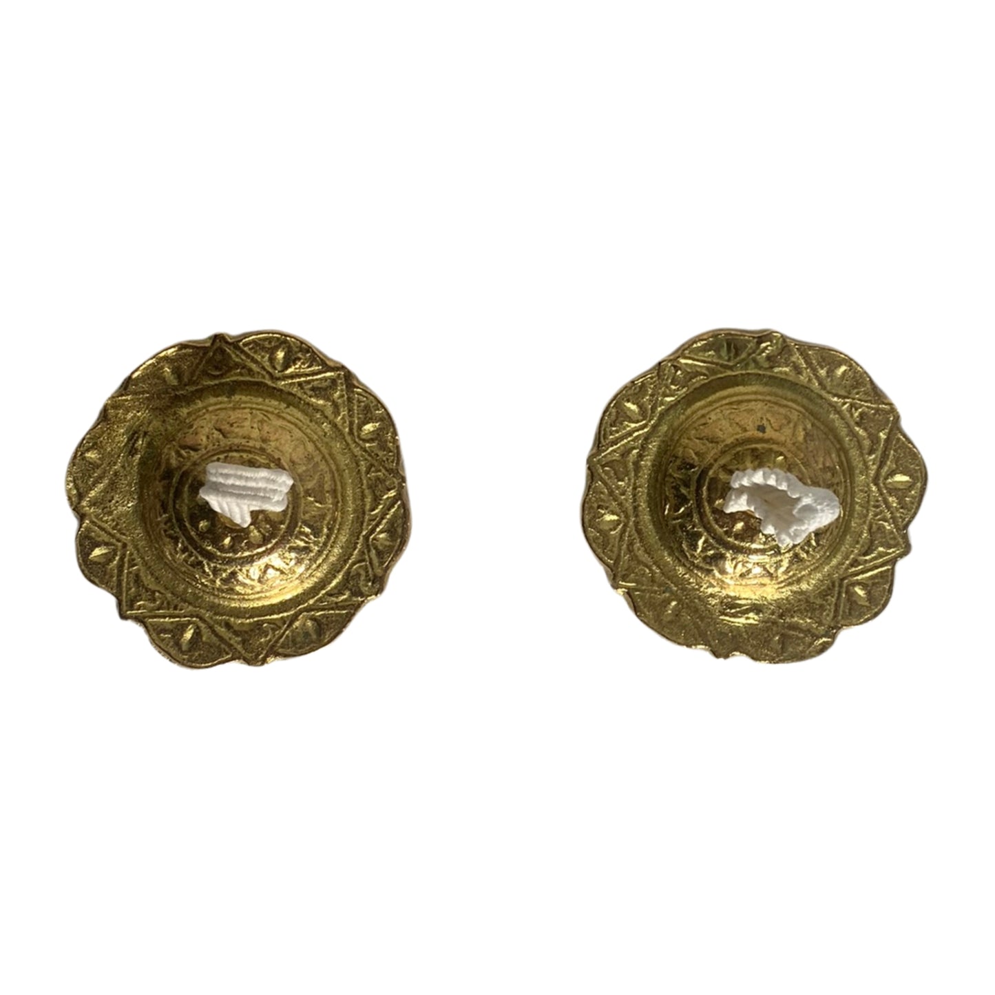 Top view of two brass finger cymbals with intricate design patterns and white fabric loops"